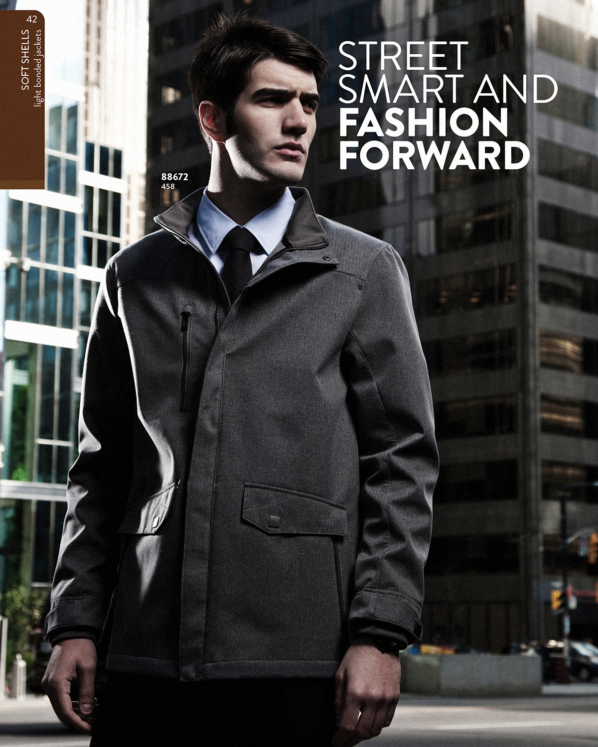 Ash City grey soft shell jacket worn with shirt and tie against downtown towers - catalog photography by Fisheye Studio Toronto