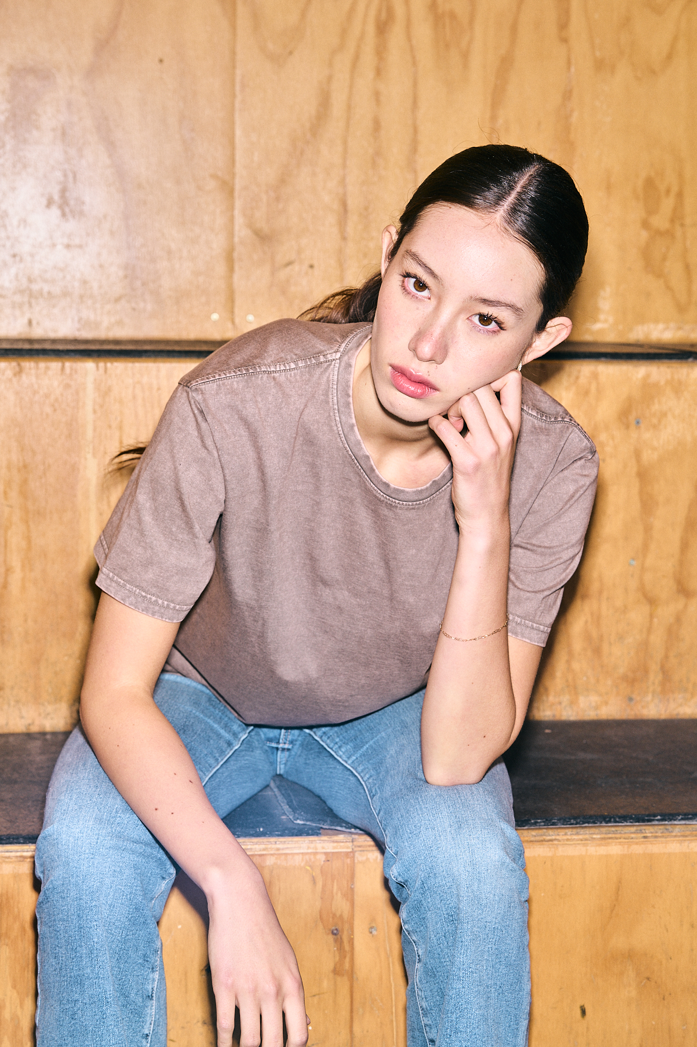 Muskoka Trail washed brown tee worn seated against a plywood wall - on-location editorial by Fisheye Studio Toronto